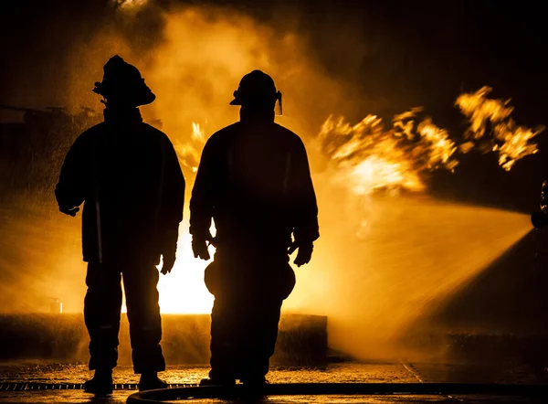 Bombeiros mangueirando um fogo — Fotografia de Stock