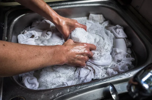 Çamaşırları krom lavaboda elle yıkıyorum..