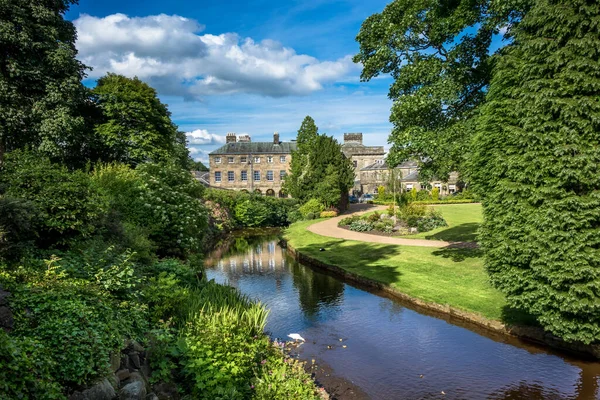 Park bahçelerinden Buxton 'daki tipik taş binaların resimli görüntüsü..