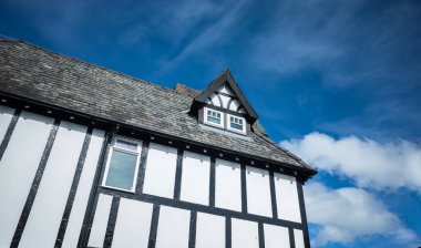 Ahşap çerçeveli küçük tavan arası pencereli sahte Tudor binası.