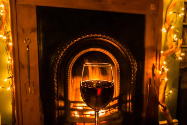 Açık ateşin yanında bir kadeh kırmızı şarap..