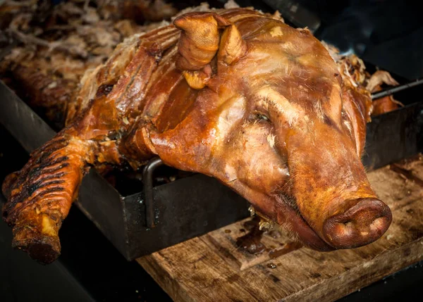 Bir ziyafette kızarmış domuz tükürmek.