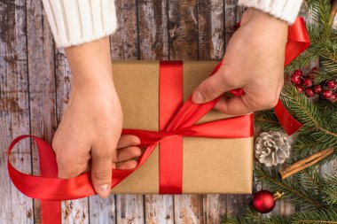 Noel arkaplanına hediye paketi koyan bir kız. Mutlu Noeller..