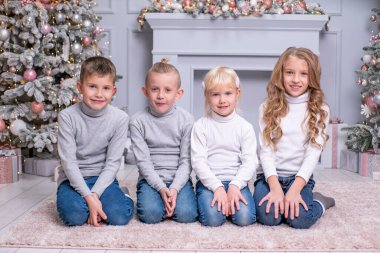 Çocuklar Noel ağacının yanında oturuyor. Noel.