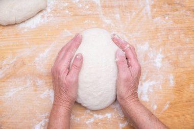 Kadın ekmeğin üstünde hamur yoğuruyor. Hamur ürünleri. Yemek pişirmek. Yakın plan. Pişirme.