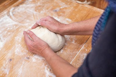 Kadın ekmeğin üstünde hamur yoğuruyor. Hamur ürünleri. Yemek pişirmek. Yakın plan. Pişirme.