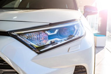 Güneşli kulübede yeni bir arabanın farları. araba arkaplanı yakın plan. 