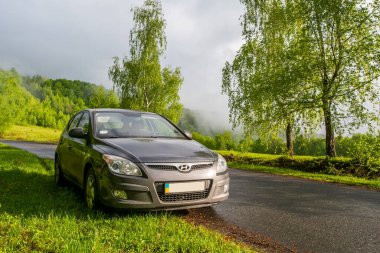 VILSHINKI, UKRAINE - 10 Haziran 2020: Hyundai ve 30 hatchback sisli dağlarda bir kır yolunda. Yazın gün doğumunda güzel bir nakliye manzarası. araba kavramları üzerine seyahat