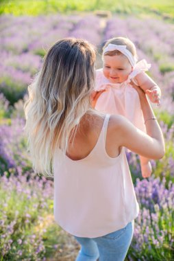 Anne ve kızı gün doğumunda lavanta tarlasında. Doğayla uyum. Mutlu çocukluk.