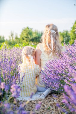 Anne ve kızı gün doğumunda lavanta tarlasında. Doğayla uyum. Mutlu çocukluk.