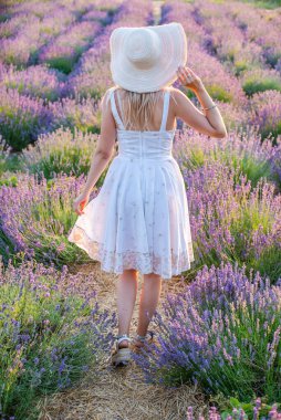 Gün doğumunda lavanta tarlasında şapkalı bir kız. Doğayla uyum..