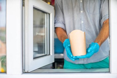  Pencereden satıcı pakette yemek servisi yapar..