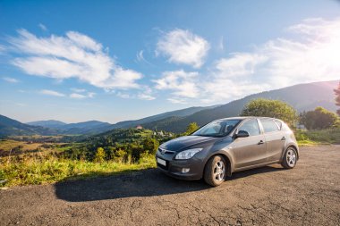 VILSHINKI, UKRAINE - 10 Haziran 2020: Hyundai ve 30 hatchback sisli dağlarda bir kır yolunda. Yazın gün doğumunda güzel bir nakliye manzarası. Araba konseptiyle seyahat. Arabayla seyahat et..