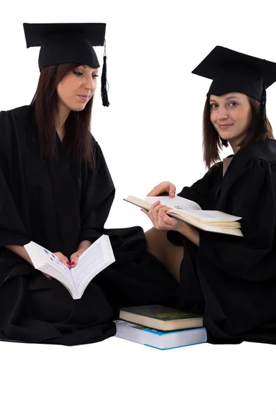 Mladé dívky ve studentské plášť s Stoh knih — Stock fotografie