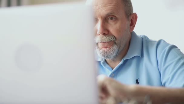 Senior man werkt en gebruik van de elektronische sigaret — Stockvideo