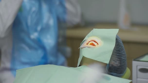 Paciente em consultório odontológico com assento facial coberto em cadeira de dentista — Vídeo de Stock