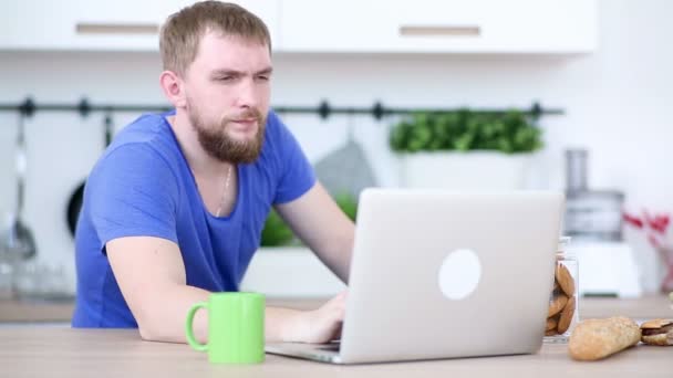 L'homme travaille avec un ordinateur portable et mange des pommes — Video