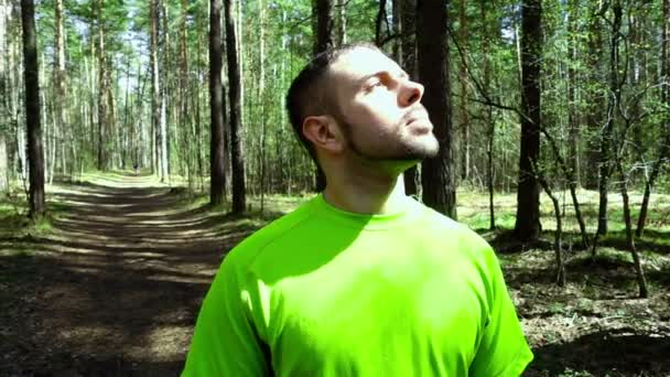 Mann blickt im Wald in die Sonne — Stockvideo