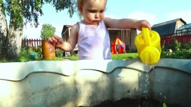 Küçük bebek kız wattering bitkiler