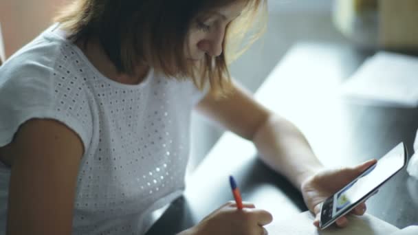 Mujer joven escribiendo en cuaderno — Vídeo de stock