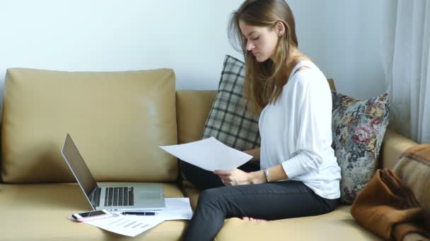 Jonge vrouw werk met documenten en het gebruik van laptop — Stockvideo