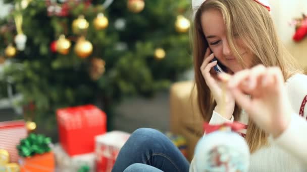 Hezká mladá dívka v vánoční čepici mluvil po telefonu — Stock video