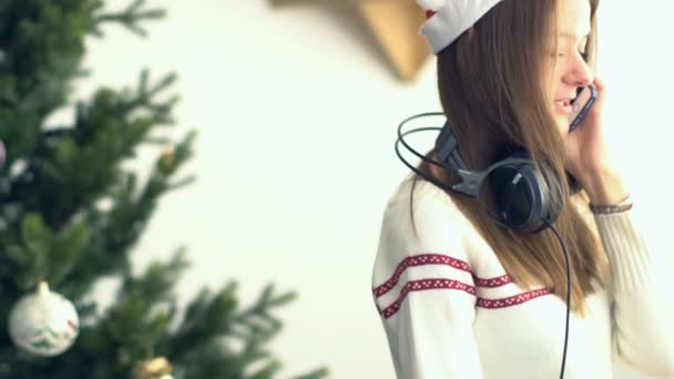 Hübsches junges Mädchen mit Weihnachtsmütze telefoniert — Stockvideo