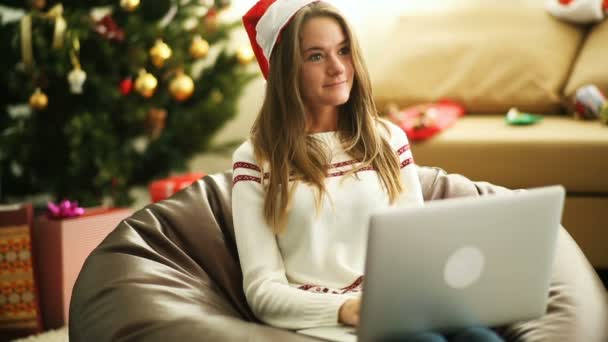 Mooi meisje schrijven brief aan de kerstman op laptop op kerstavond — Stockvideo