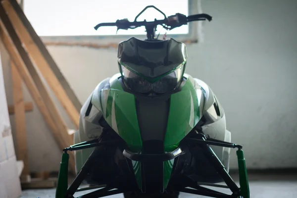 Snowmobile verde na garagem — Fotografia de Stock