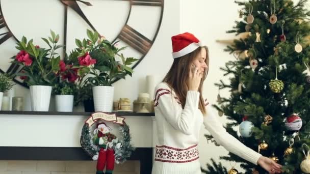 Chica bonita hablando por teléfono cerca del árbol de Navidad — Vídeos de Stock