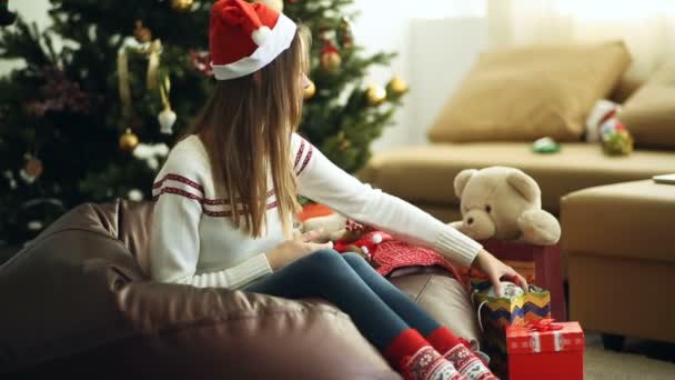 Jeune belle fille enveloppe un cadeau de Noël — Video