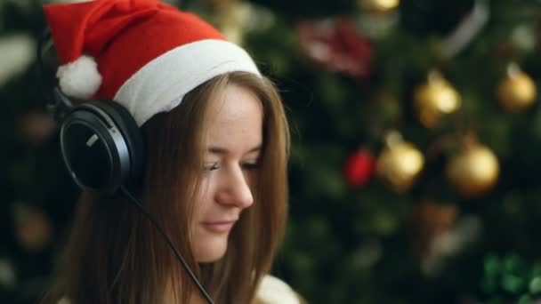 Ładna Brunetka w Boże Narodzenie słuchać muzyki i śpiewać — Wideo stockowe