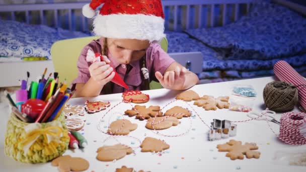 Little cute dziewczyna dekoruje ciasteczka — Wideo stockowe