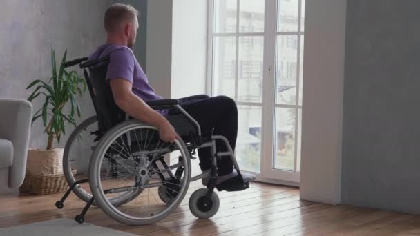 Άνδρας που κάθεται σε αναπηρική καρέκλα στο σπίτι — Αρχείο Βίντεο