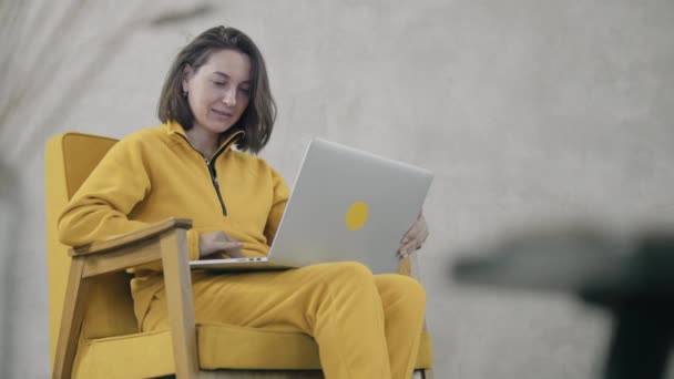 Mulher em amarelo usando laptop — Vídeo de Stock