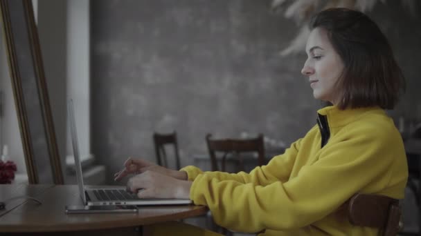 使用笔记本电脑的黄衣妇女 — 图库视频影像