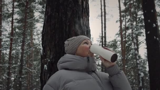 Frau ruht mit Tee in Thermoskanne im Wald — Stockvideo