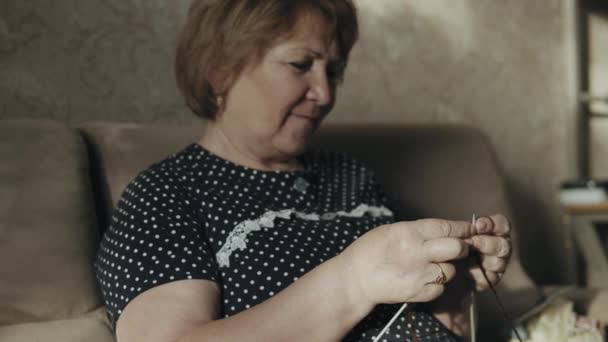 Пожилая женщина вязание дома — стоковое видео