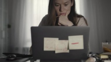 Evde dizüstü bilgisayarda çalışan bir kadın.