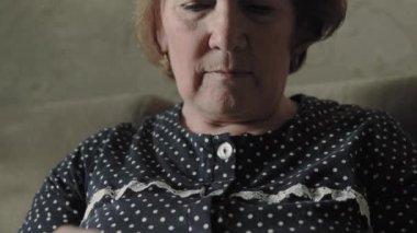 Yaşlı kadın evde örgü örüyor.