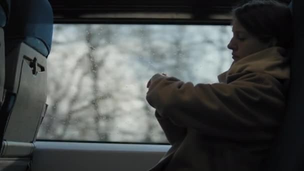Genç kadın trenle seyahat ederken akıllı saatini kullanır. — Stok video