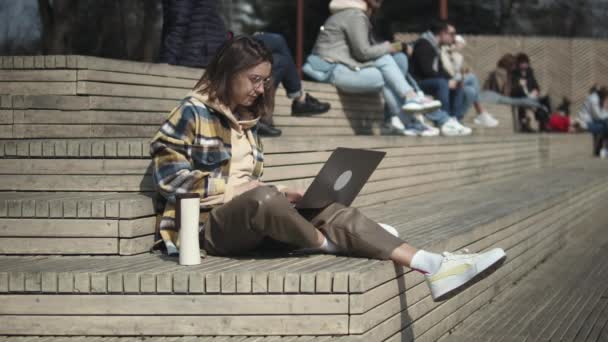 Mulher usando laptop enquanto sentado em escadas — Vídeo de Stock