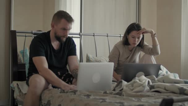 Pari sängyssä käyttäen elektronisia laitteita — kuvapankkivideo