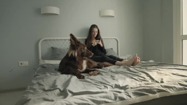 Femme avec son chien dans son lit — Video