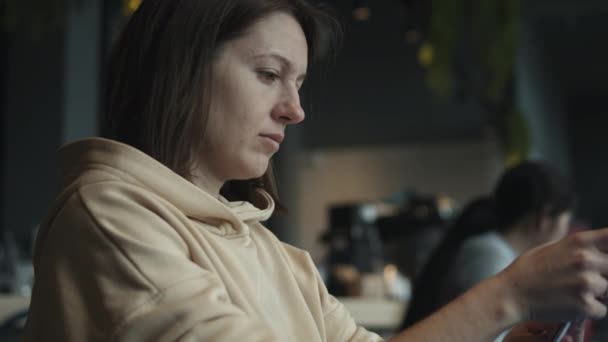 Frau mit Smartphone im Café — Stockvideo