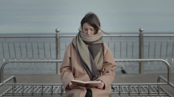 Lectura femenina Un libro contra el paisaje marino — Vídeos de Stock