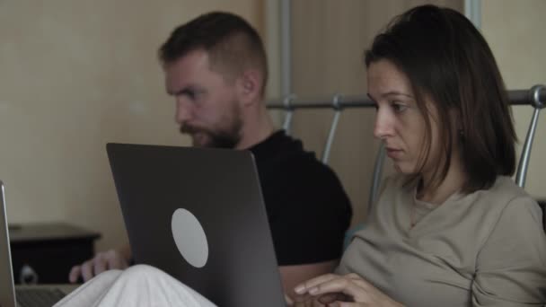 Casal na cama usando computadores portáteis — Vídeo de Stock