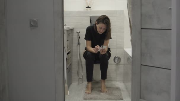 Frau mit Handy auf Toilette — Stockvideo