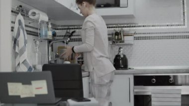 Kadın evde uzaktan çalışmak için yemek pişiriyor.