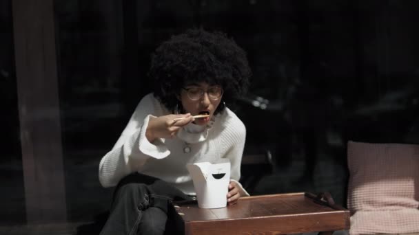 若い混合レースガールはストリートフードを食べている — ストック動画